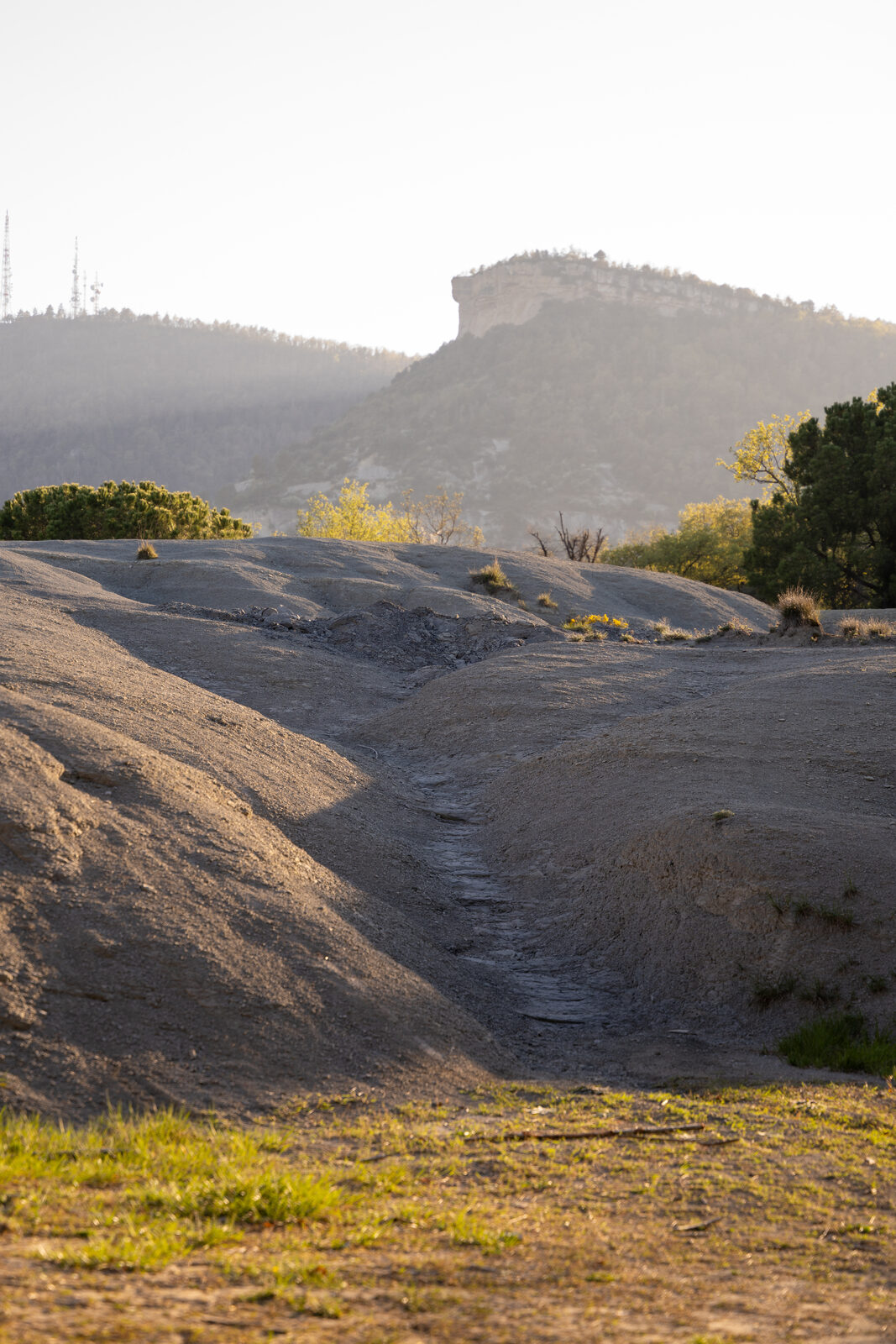 Terreny erosionat del Puig amb vista a la muntanya i llum daurada